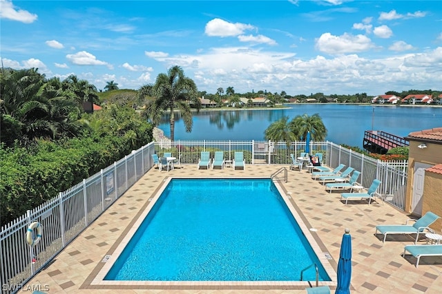 view of swimming pool with a water view and a patio