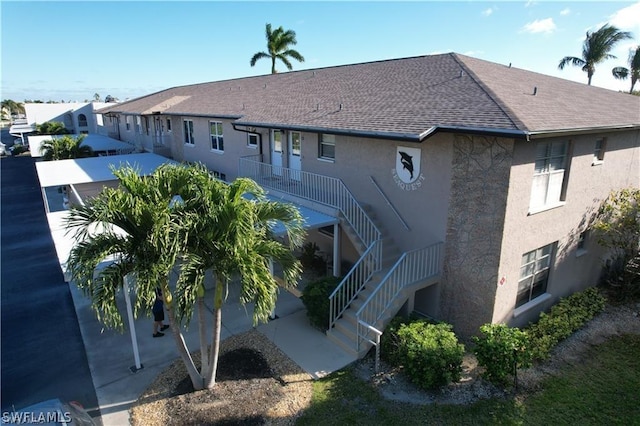4563 SE 5th Pl Unit 205, Cape Coral, FL 33904 - back of property featuring stairs, stucco siding, and roof with shingles