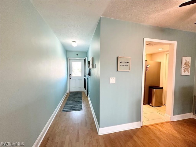 4563 SE 5th Pl Unit 205, Cape Coral, FL 33904 - hall featuring a textured ceiling, baseboards, and wood finished floors