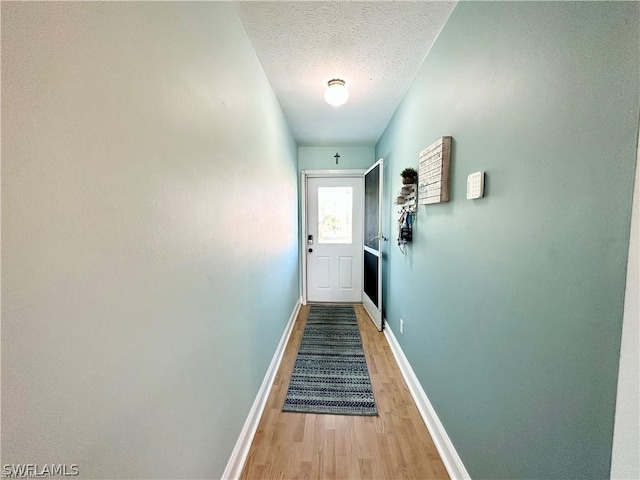 hallway with hardwood / wood-style flooring and a textured ceiling