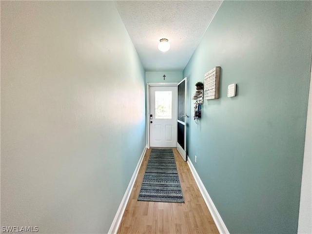 4563 SE 5th Pl Unit 205, Cape Coral, FL 33904 - entryway featuring baseboards, a textured ceiling, and light wood-style flooring