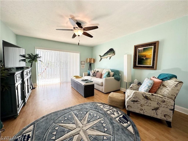 4563 SE 5th Pl Unit 205, Cape Coral, FL 33904 - living room with a textured ceiling, light wood-style flooring, baseboards, and a ceiling fan