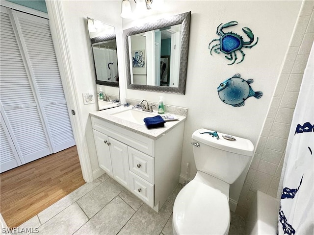 bathroom featuring vanity, tile patterned floors, and toilet