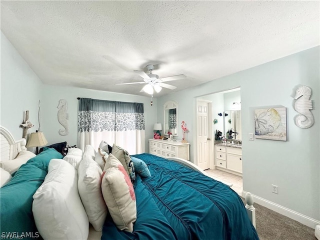 4563 SE 5th Pl Unit 205, Cape Coral, FL 33904 - bedroom with a textured ceiling, baseboards, a ceiling fan, light carpet, and ensuite bath