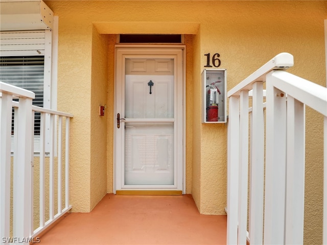 doorway to property featuring a balcony and stucco siding