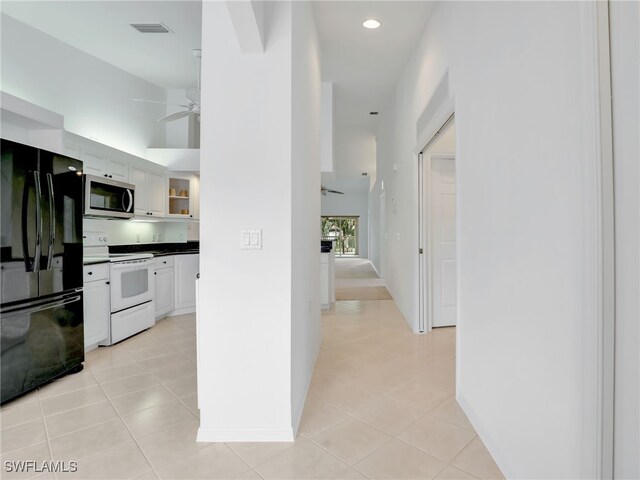 corridor with light tile patterned floors and vaulted ceiling