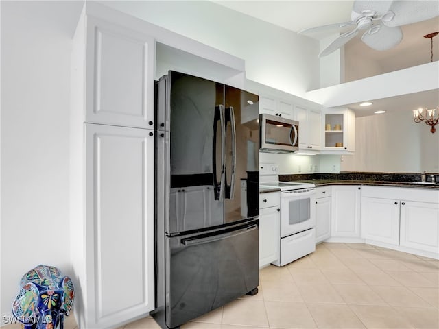 kitchen featuring white electric range oven, dark countertops, stainless steel microwave, glass insert cabinets, and freestanding refrigerator