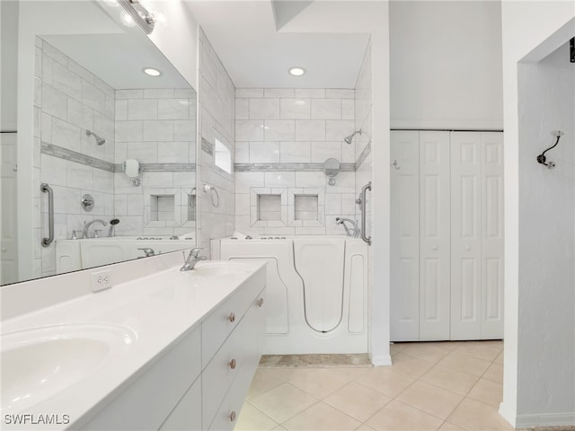 bathroom with a bath, vanity, and tile patterned floors