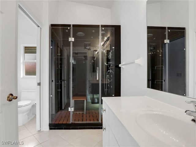 bathroom with a stall shower, vanity, toilet, and tile patterned floors