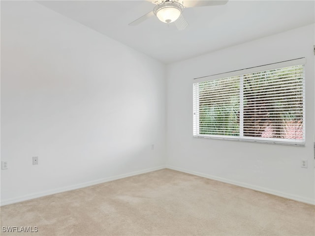 unfurnished room with light colored carpet and ceiling fan