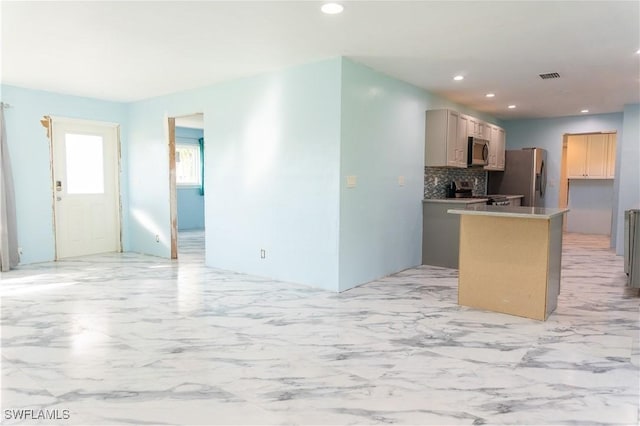 kitchen with appliances with stainless steel finishes and tasteful backsplash