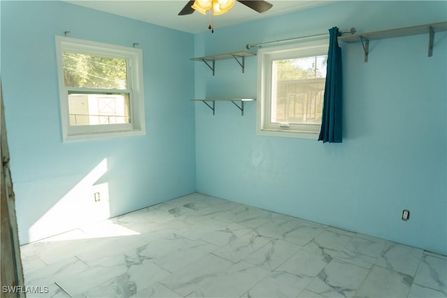 empty room featuring a wealth of natural light and ceiling fan