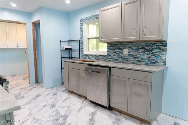 kitchen featuring dishwasher, gray cabinets, and backsplash