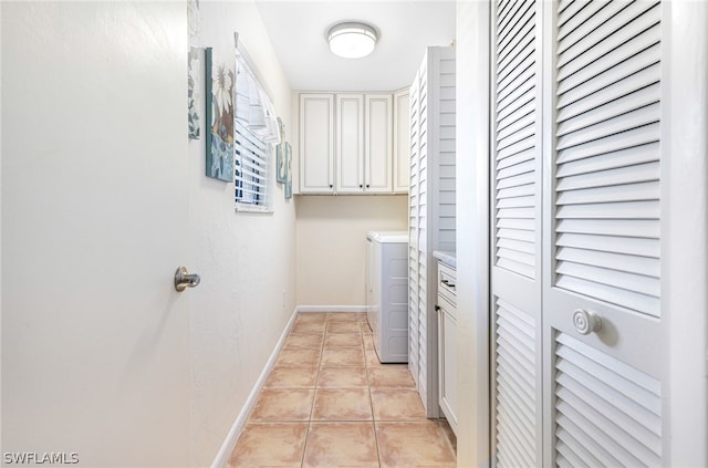 laundry area with cabinets, light tile patterned floors, and independent washer and dryer