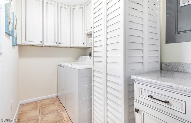 washroom with cabinets, electric panel, light tile patterned flooring, and washing machine and clothes dryer