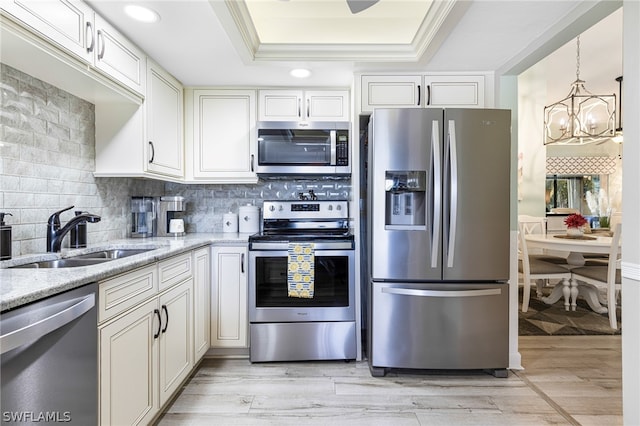 kitchen featuring a raised ceiling, white cabinetry, sink, and stainless steel appliances