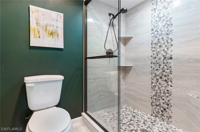 bathroom featuring toilet and tiled shower