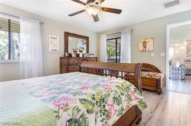 bedroom featuring ceiling fan, light wood-type flooring, and multiple windows