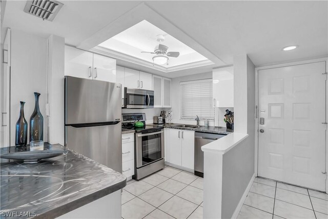 kitchen featuring white cabinets, stainless steel appliances, light tile patterned floors, and ceiling fan