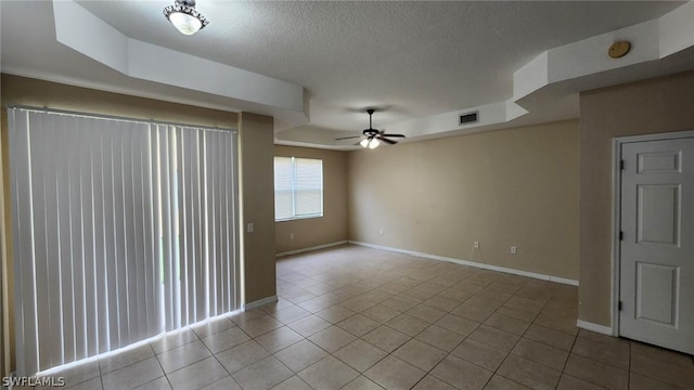 tiled empty room with a textured ceiling and ceiling fan