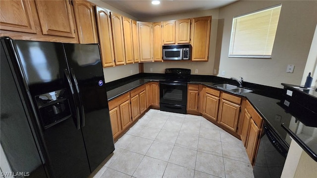 kitchen with black appliances, light tile patterned flooring, sink, and dark stone counters