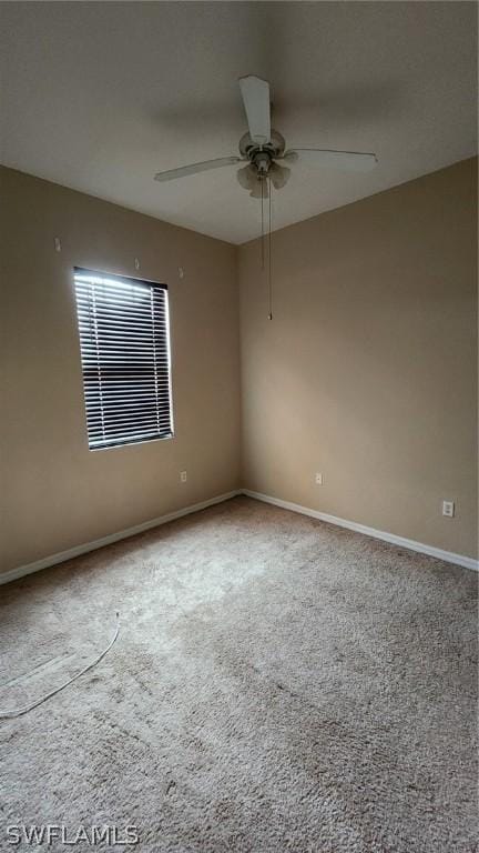 carpeted spare room featuring ceiling fan