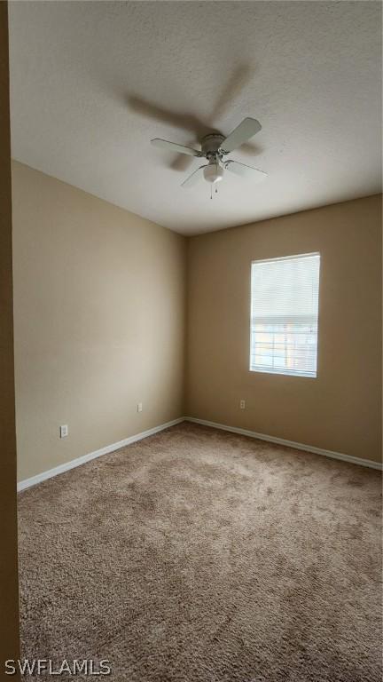 empty room featuring ceiling fan and carpet floors