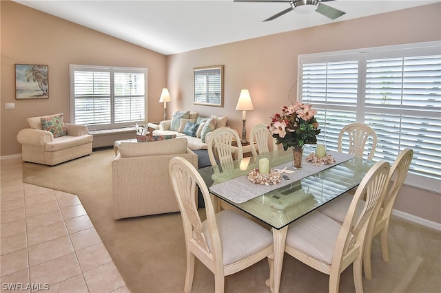 tiled dining area with ceiling fan and vaulted ceiling