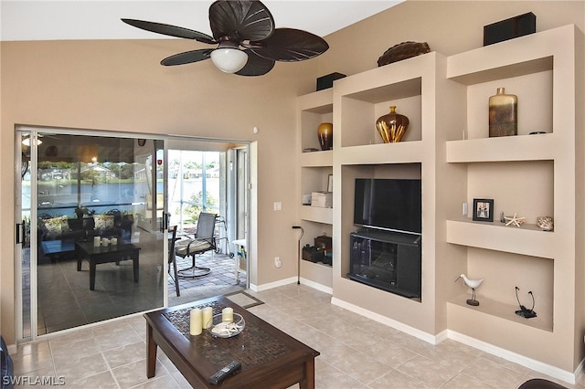 living room featuring built in shelves, ceiling fan, and tile patterned flooring