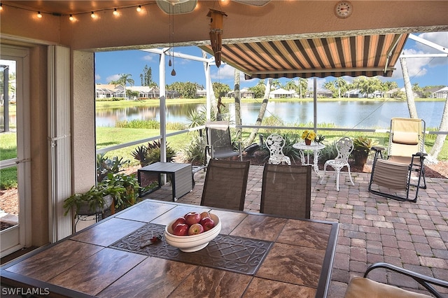 sunroom featuring a water view