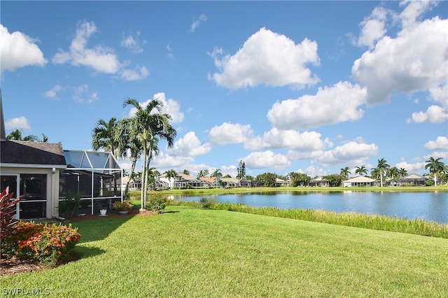 view of yard featuring a water view and glass enclosure