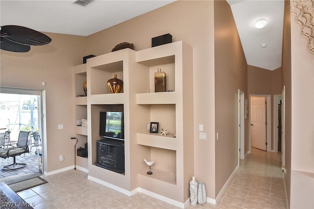 living room with vaulted ceiling, built in features, and light tile patterned floors