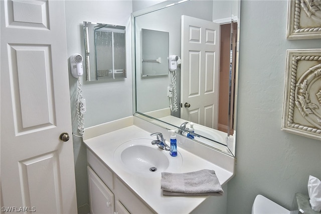 bathroom featuring vanity and toilet