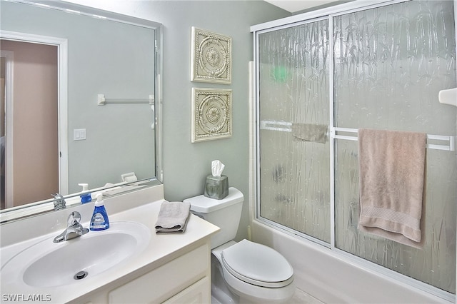 full bathroom featuring vanity, enclosed tub / shower combo, and toilet