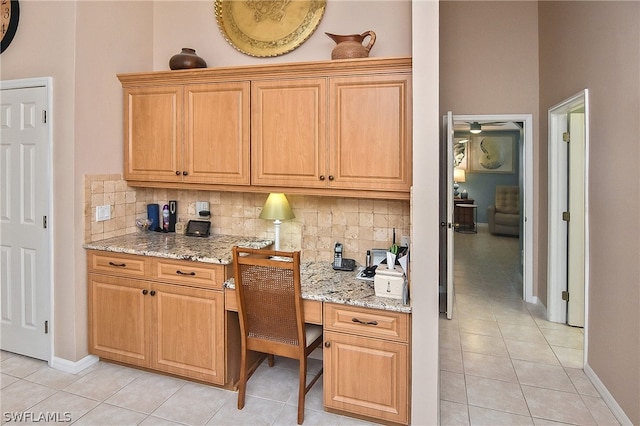 kitchen featuring light tile patterned floors, tasteful backsplash, and light stone countertops