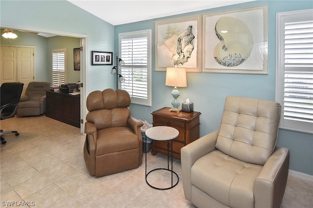 sitting room featuring light tile patterned flooring and lofted ceiling