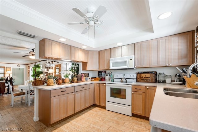 kitchen with a tray ceiling, kitchen peninsula, light brown cabinets, and white appliances