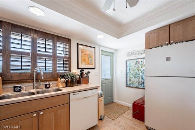 kitchen with white appliances, a tray ceiling, ceiling fan, sink, and light hardwood / wood-style flooring