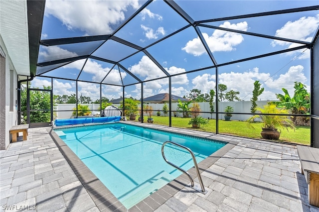 view of swimming pool featuring a patio, glass enclosure, and a lawn