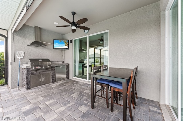 view of patio featuring area for grilling, ceiling fan, and exterior kitchen