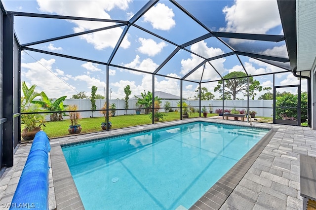 view of swimming pool with a patio area, glass enclosure, and a lawn