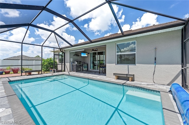 view of pool with ceiling fan, a patio area, and glass enclosure