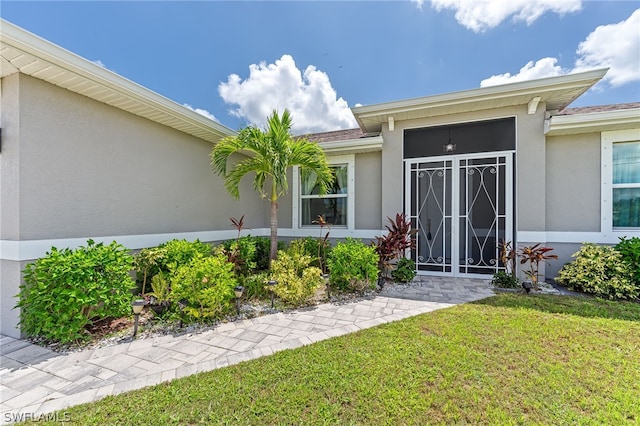 entrance to property featuring a lawn