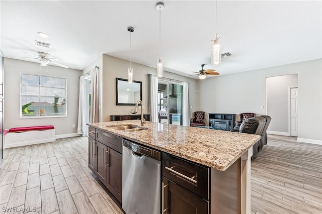 kitchen with dark brown cabinetry, sink, hanging light fixtures, a center island with sink, and dishwasher