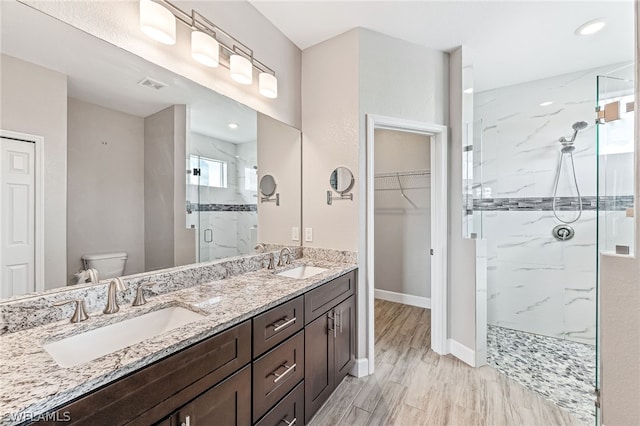 bathroom with walk in shower, vanity, toilet, and hardwood / wood-style floors