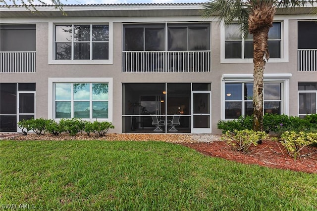 rear view of property featuring a lawn