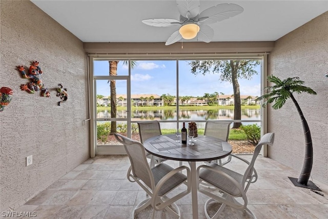 sunroom / solarium with a water view and ceiling fan