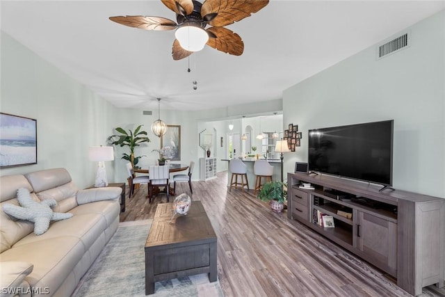 living room featuring hardwood / wood-style floors and ceiling fan