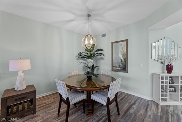 dining area with dark hardwood / wood-style flooring and an inviting chandelier