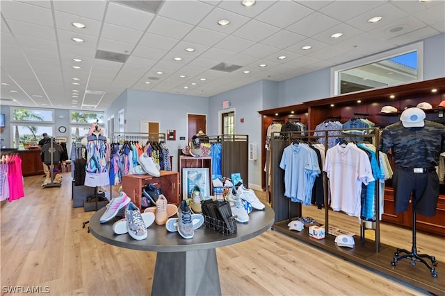 interior space featuring a paneled ceiling and light hardwood / wood-style flooring